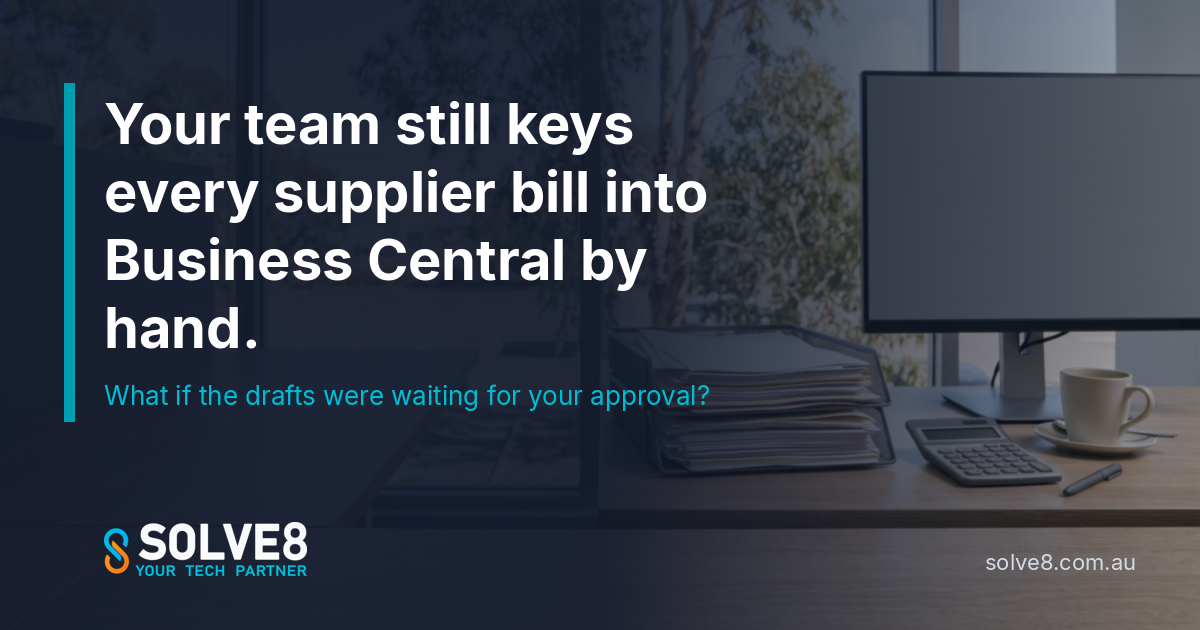 An accounts payable desk in an Australian office with a stack of supplier invoices, a monitor and a window: supplier bills drafted in Business Central without keying