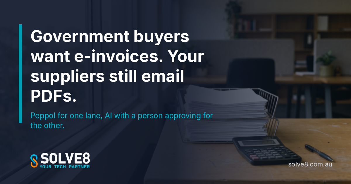 Accounts payable desk in an Australian finance office with a tall stack of paper supplier invoices in a wire tray beside a calculator, the PDFs that Peppol alone will not clear